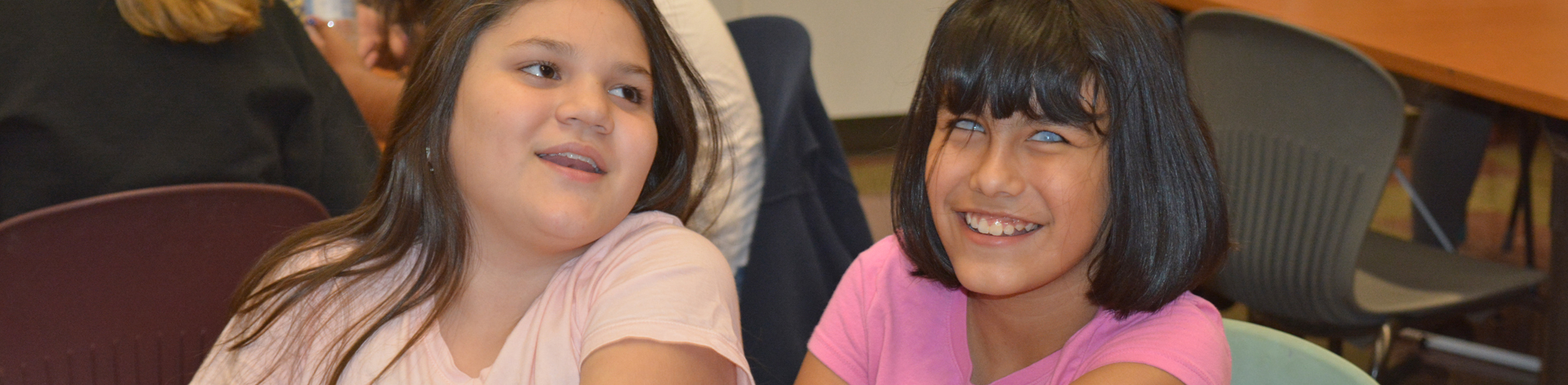 Two blind girls smile and laugh together.